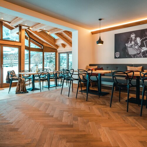 Gemütliches Café mit Holzbalken, großen Fenstern