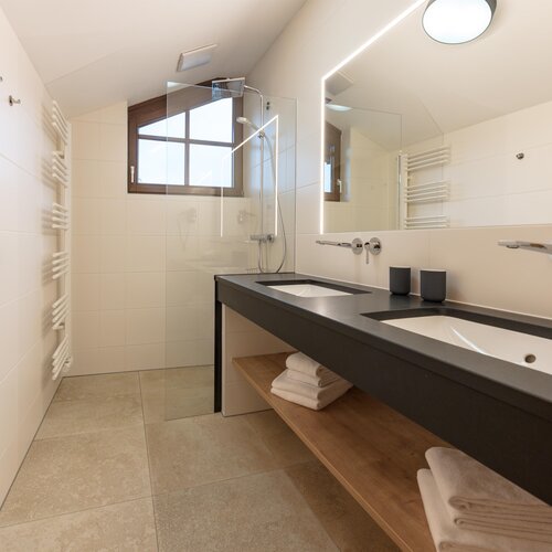 Modernes Badezimmer mit Doppelwaschbecken und Glasdusche