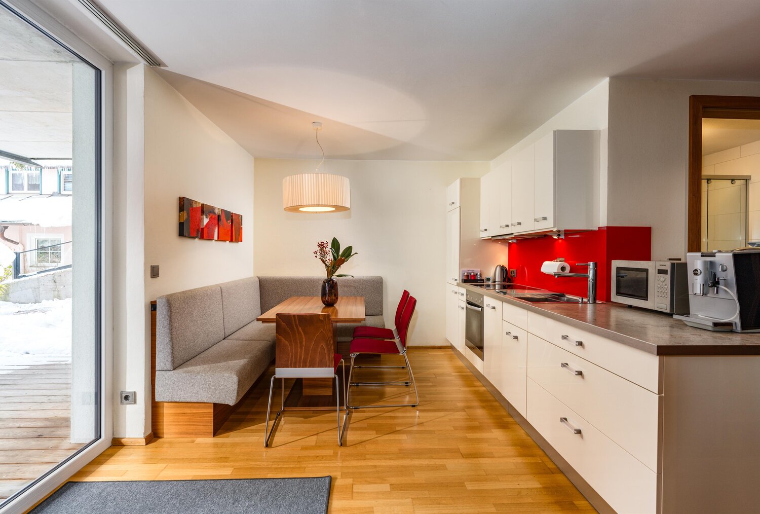Open-plan kitchen and dining area with red backsplash