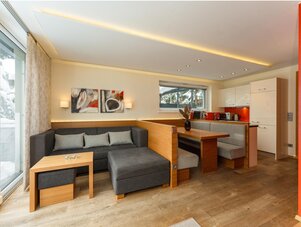 Open-plan living area with grey sectional sofa and dining nook