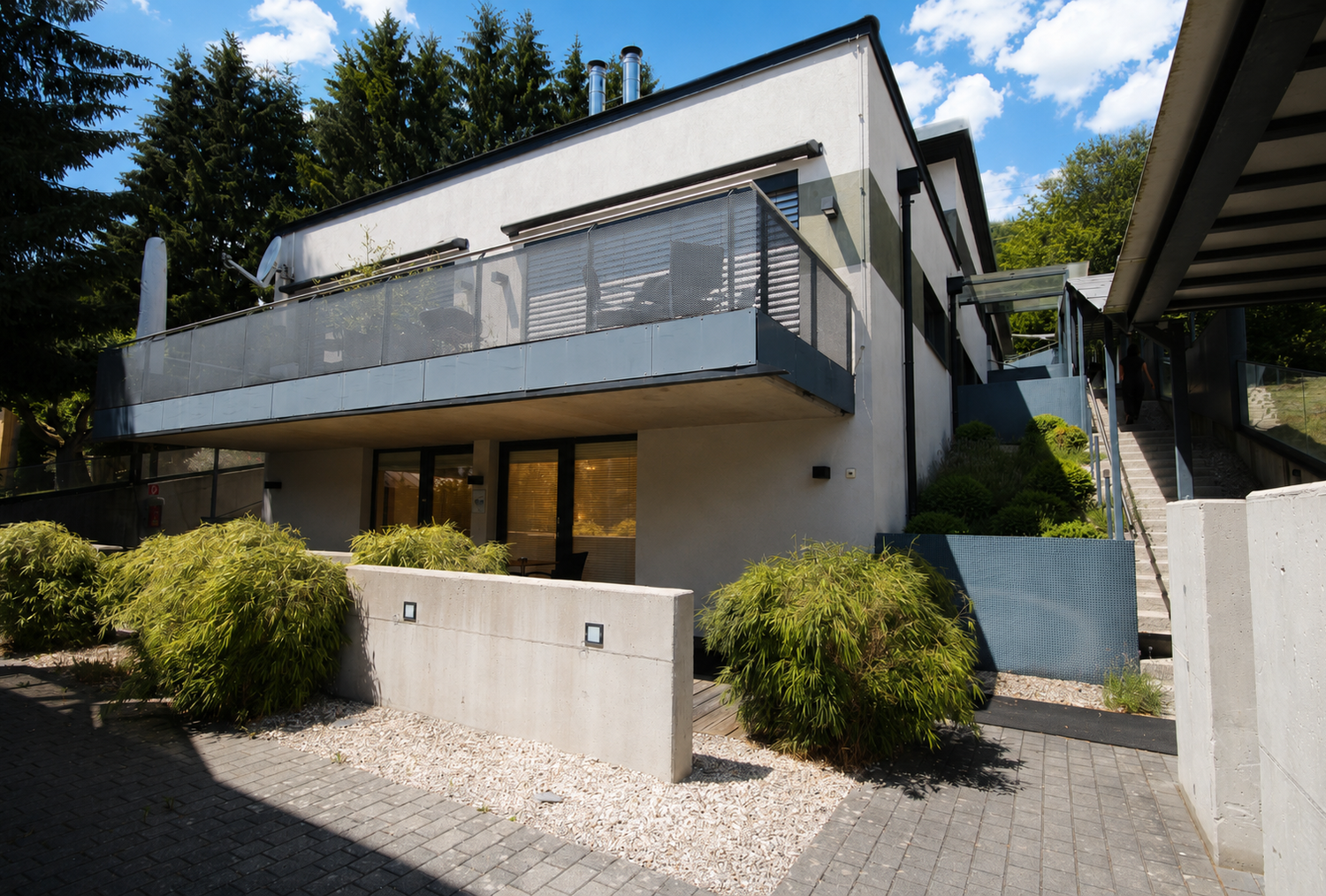 Modern two-story building with glass balcony and landscaped grounds