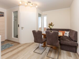 Cozy dining area with brown upholstered corner bench and chairs