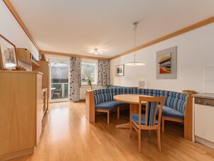 Gemütliches Wohnzimmer mit blau gestreiftem Ecksofa und runder Tisch