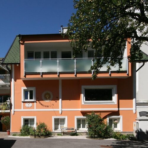 Orangefarbenes Haus mit Balkon und Garten