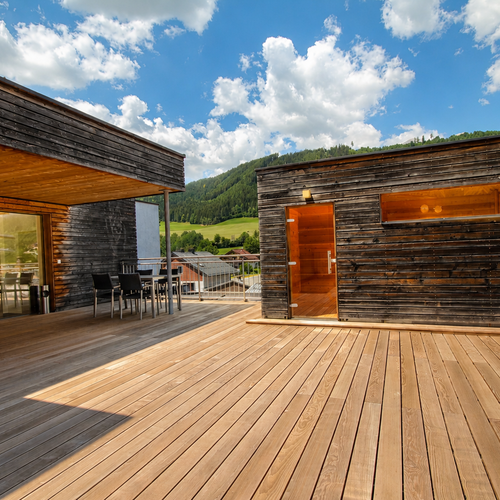Holzterrasse mit Outdoor-Möbeln und Bergblick
