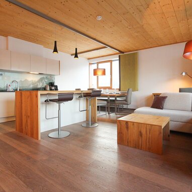 Offener Wohnbereich mit Kücheninsel und Sofa | © SCHLADMING-APPARTEMENTS