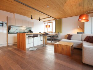 Open-plan kitchen and living area with wooden floors. | © SCHLADMING-APPARTEMENTS