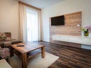 Wohnzimmer mit Holz-Wand und Wandfernseher