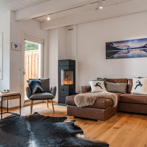 Gemütliches Wohnzimmer mit braunem Ledersofa und Kamin