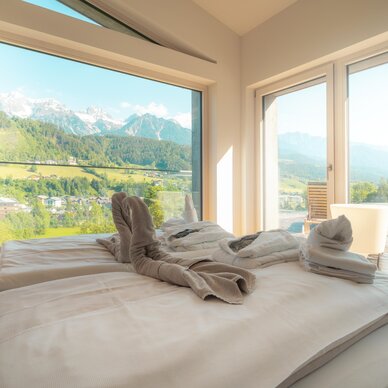 Modernes Schlafzimmer mit Bergblick und gefalteten Handtüchern auf dem Bett | © TIEBER