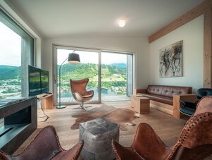 Helles modernes Wohnzimmer mit großen Glastüren und Bergblick.