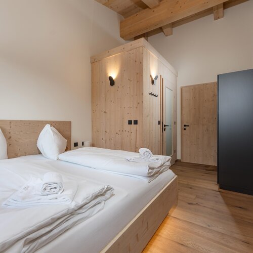 Modernes Schlafzimmer aus Holz mit großem Bett und Kleiderschrank