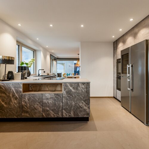 Moderne Küche mit Marmorkücheninsel und Edelstahlgeräten