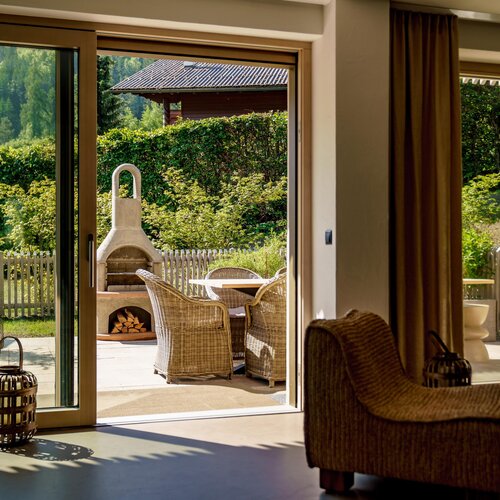 Wohnzimmer öffnet sich zur sonnigen Terrasse mit Grill.