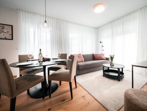 Modernes Wohnzimmer mit rundem Esstisch und Sofa