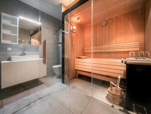 Zeitgenössisches Badezimmer mit Glasabtrennung und Holzsauna