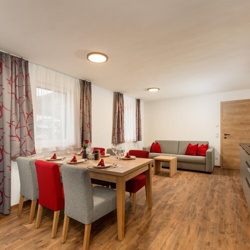 Open-plan dining area and living room with red accents