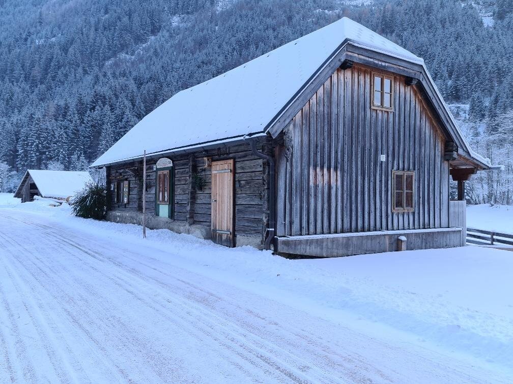 Snowy rural cabin with wooden walls in mountain landscape