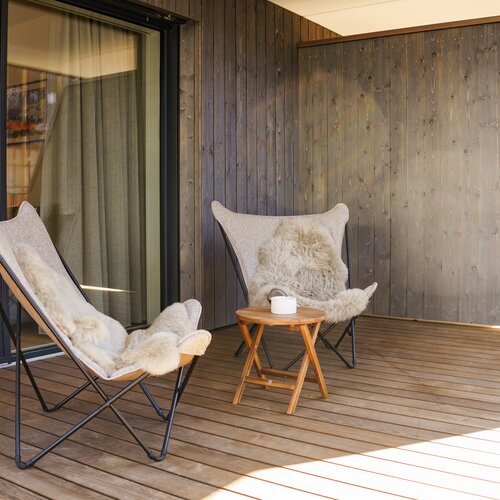 Außenbalkon mit Sitzgelegenheiten und Fellauflagen