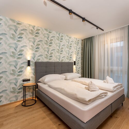 Hotelzimmer mit grünem Blattmuster und zwei Betten