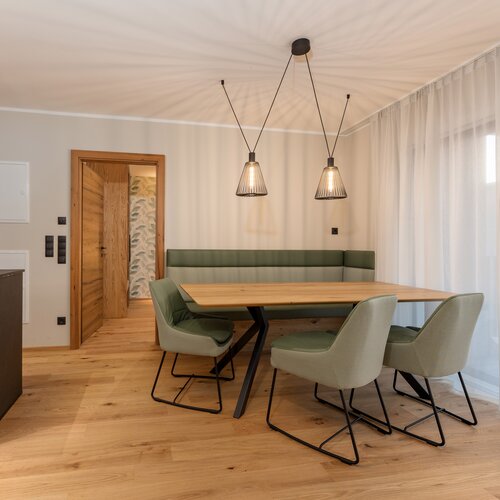 Moderner Essbereich mit Holztisch und grünen Stühlen