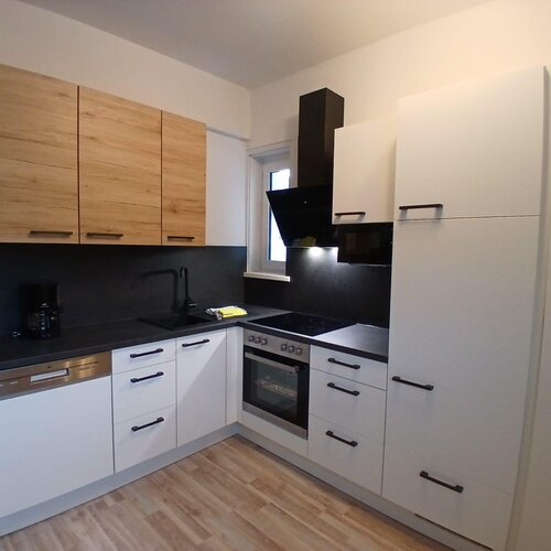Modern kitchen with white cabinets and black countertops