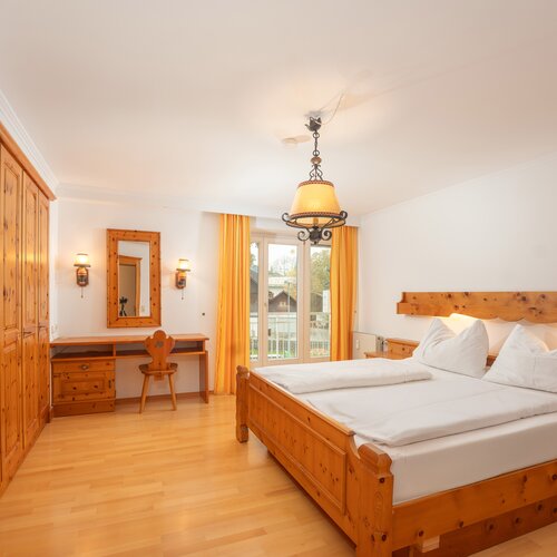 Wooden hotel room with two twin beds and wardrobe
