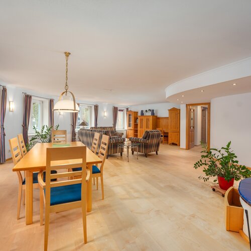 Bright open living area with dining table and plaid sofas