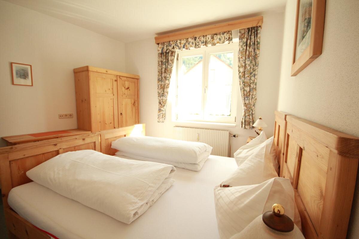 Gemütliches Schlafzimmer aus Holz mit zwei Betten und Kleiderschrank