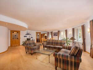 Spacious living room with plaid sofas and glass coffee table