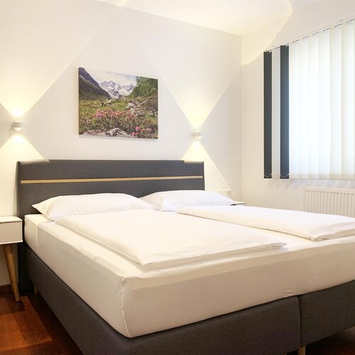 Modernes Hotelzimmer mit großem Bett und Wandbild