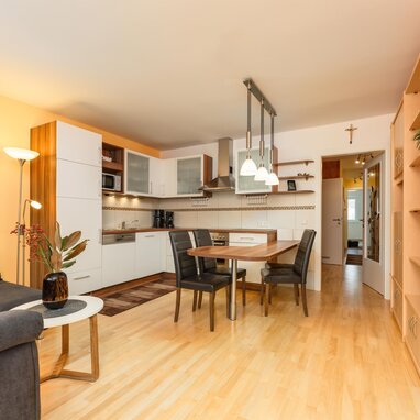 Offener Wohnbereich mit Sofa, Küche und Essbereich.