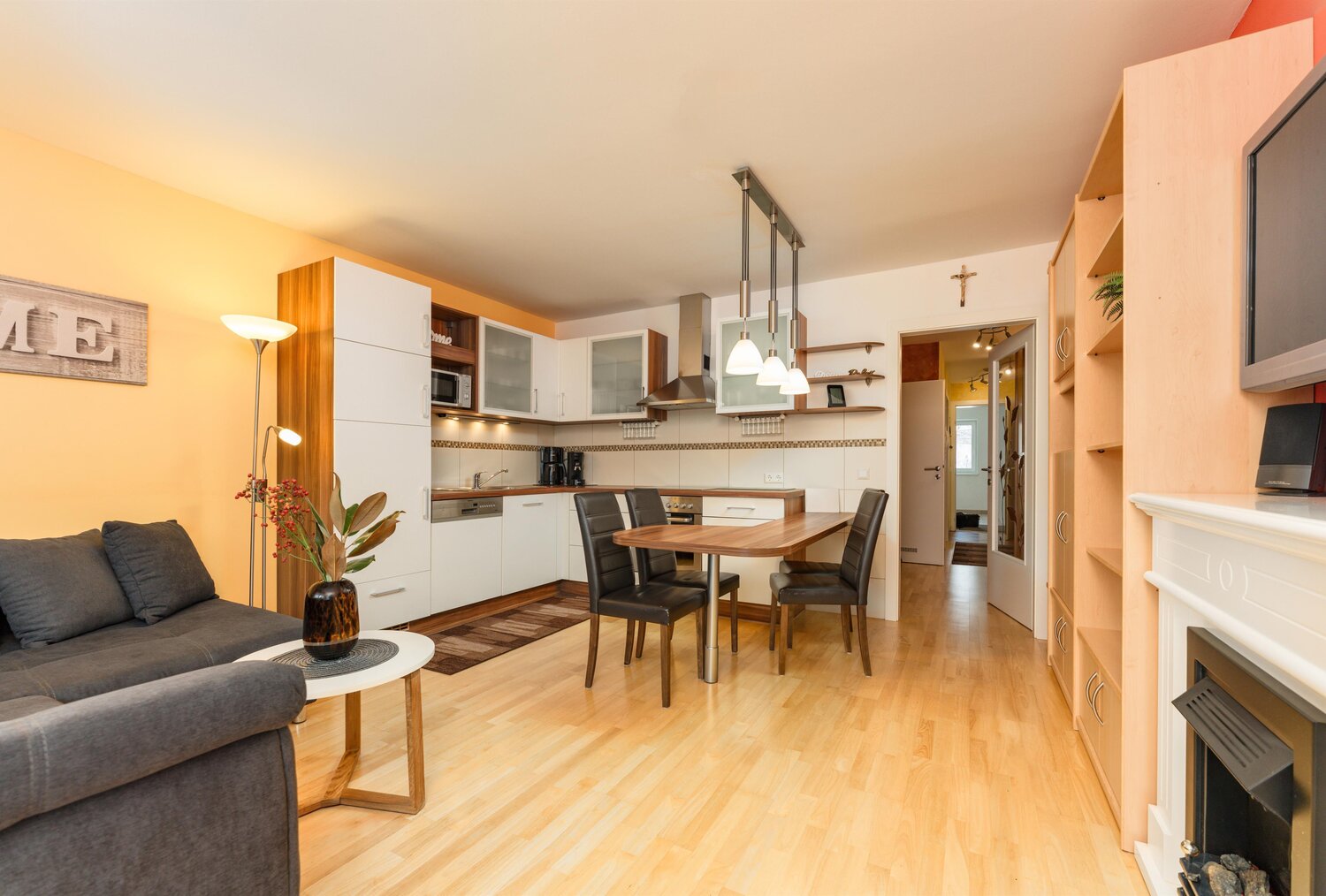 Offener Wohnbereich mit Sofa, Küche und Essbereich.