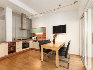 Moderne offene Küche mit Esstisch und TV.