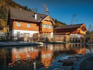 Holz-Chalet neben einem spiegelnden Pool