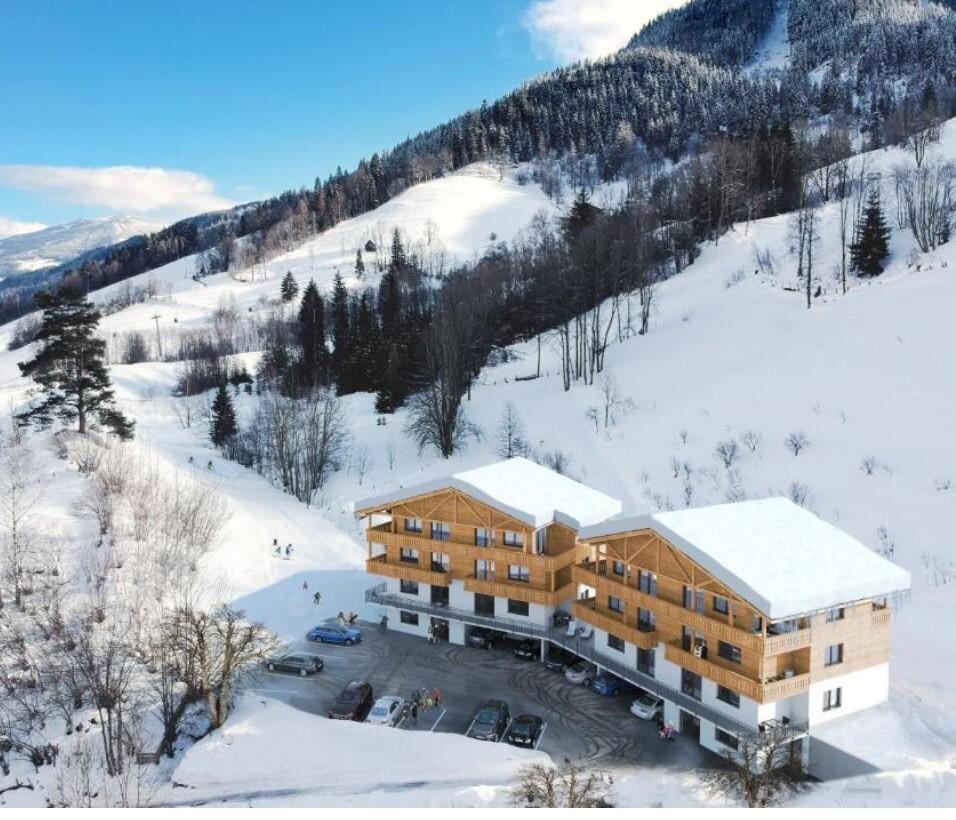 Schneebedeckte Berghütte mit holzverkleideten Chalets