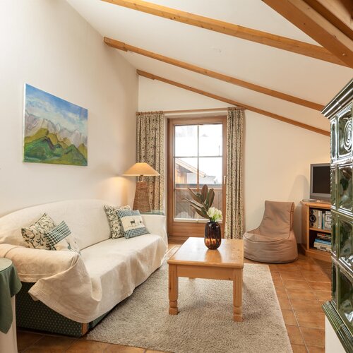 Gemütliches Wohnzimmer mit weißer Couch und Holzbalken