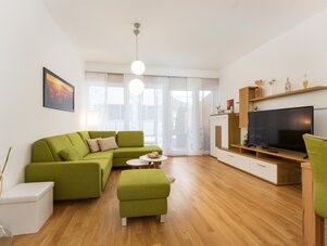 Living room with green sectional sofa and TV unit