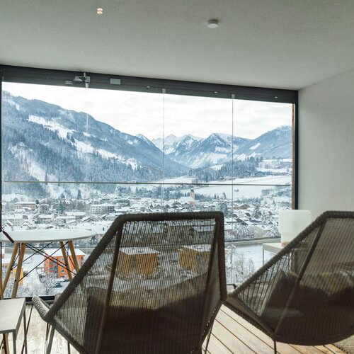 Cozy balcony seating with snow-covered mountain view