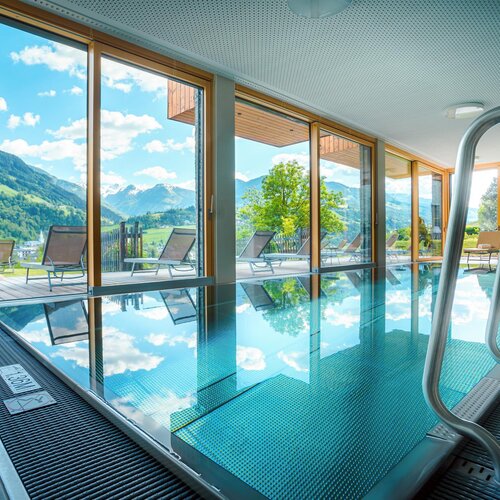 Indoor pool surrounded by glass walls and mountains