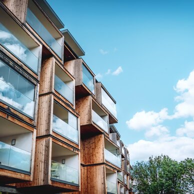 Modernes mehrstöckiges Wohngebäude aus Holz mit Glasbalkonen