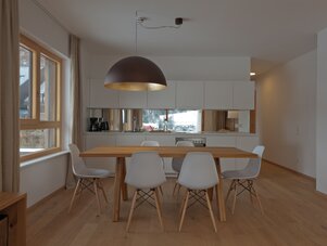 Modern kitchen and dining area with wooden table | © {your name}