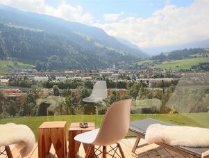 Balcony seating with glass railing overlooking valley and mountains