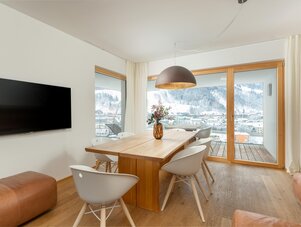 Modern dining area with a wooden table and mountain view