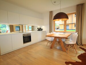 Bright modern kitchen and dining area with wooden table