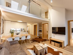 Open-plan living area with dining, kitchen, and loft