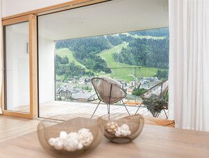 Living room with sliding glass doors to balcony overlooking valley and village