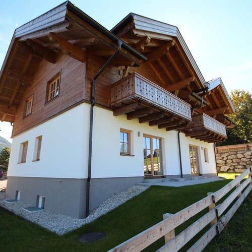 Wooden chalet-style house with balconies and lawn