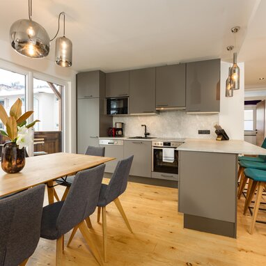Moderne Küche mit grauen Unterschränken, Insel und Esstisch