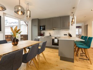 Open-plan kitchen and dining area with gray cabinets and island